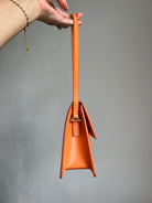 Jacquemus Orange Le Bambino Long Leather Shoulder Bag, crafted from luxurious orange leather. Features a sleek silhouette, spacious interior, and versatile design, perfect for adding a touch of luxury to any outfit.