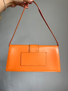 Jacquemus Orange Le Bambino Long Leather Shoulder Bag, crafted from luxurious orange leather. Features a sleek silhouette, spacious interior, and versatile design, perfect for adding a touch of luxury to any outfit.